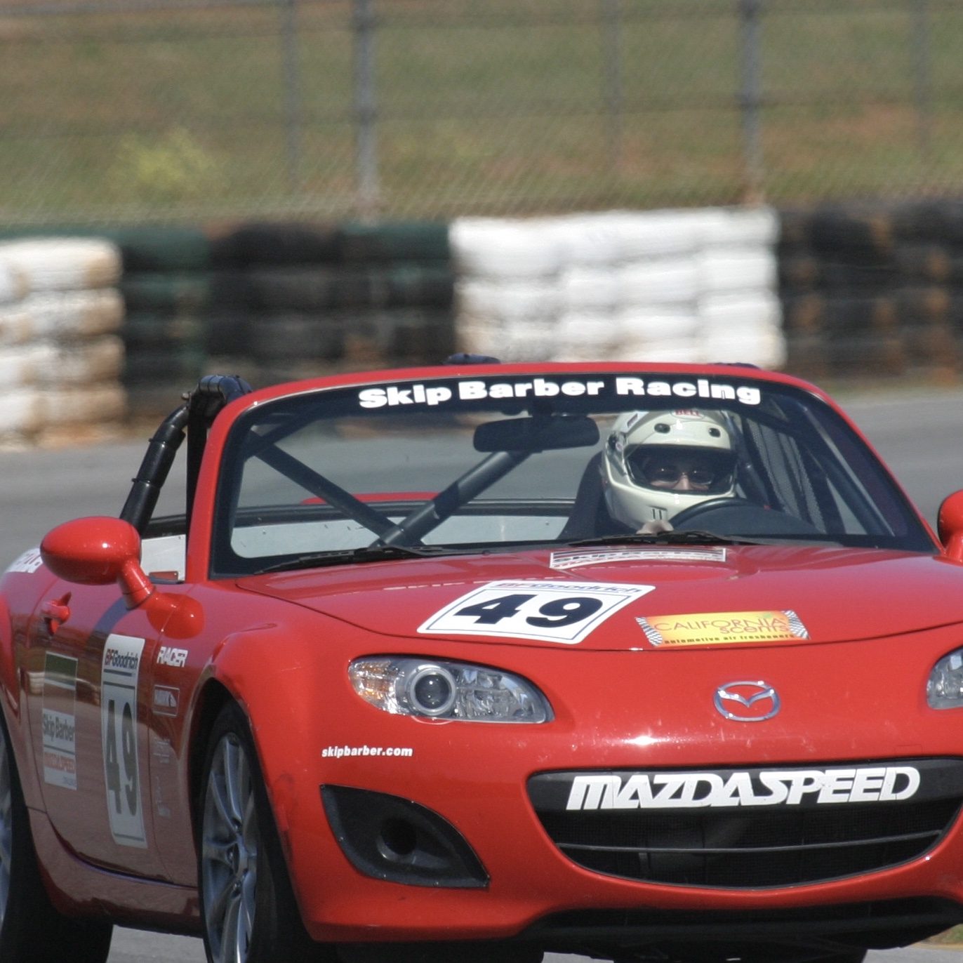 Matt Jancer with a red Mazda MX-5 race car at Skip Barber Racing School